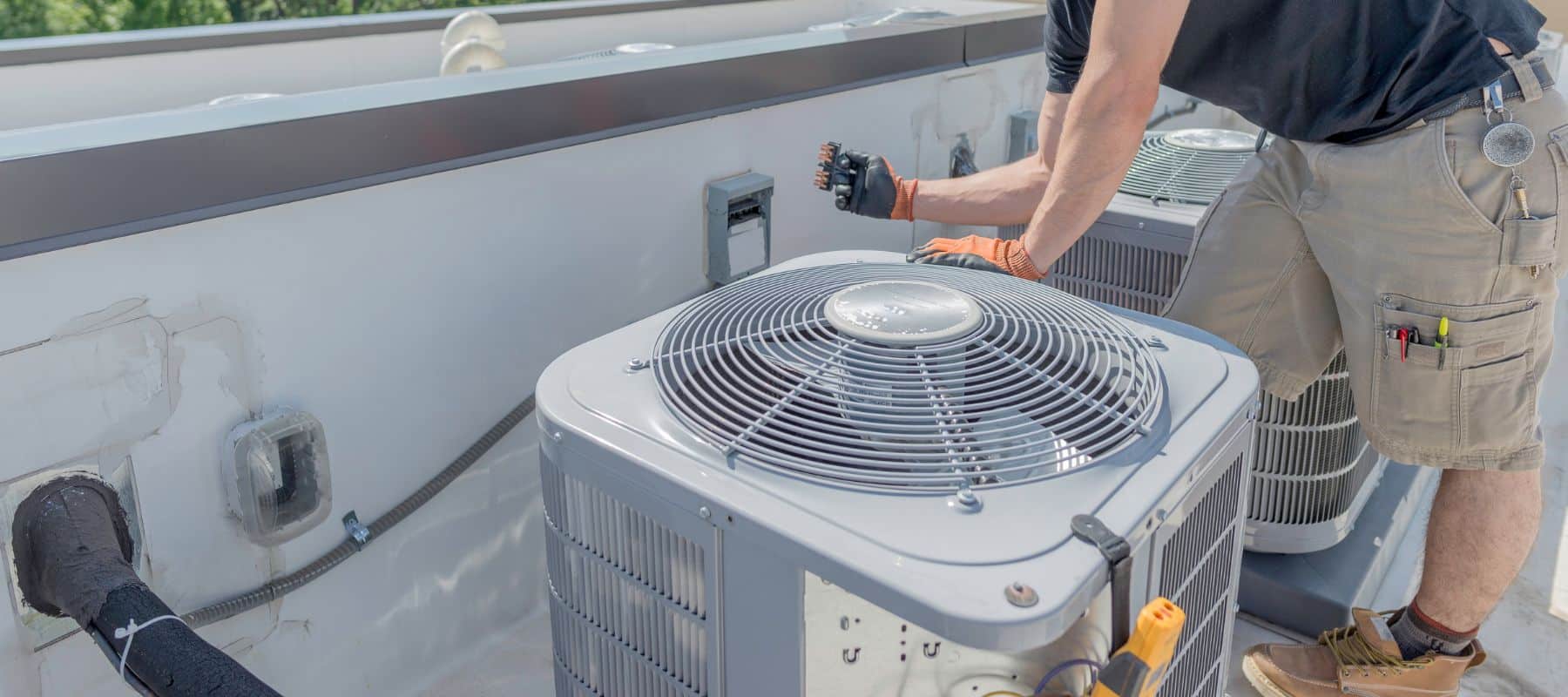 maintenance happening on an outdoor hvac unit on top of a commercial building