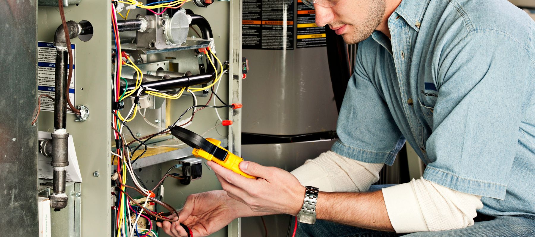 technician performing maintenance on a furnace