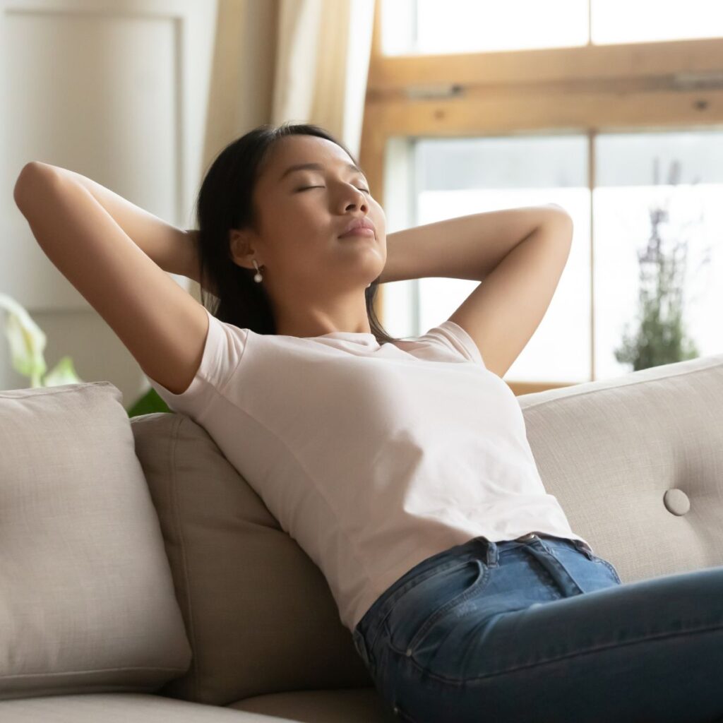 woman relaxing on the couch in her comfortable, insulated home