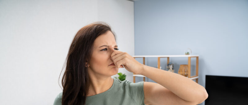 woman reacting to her heater smelling after turning it on