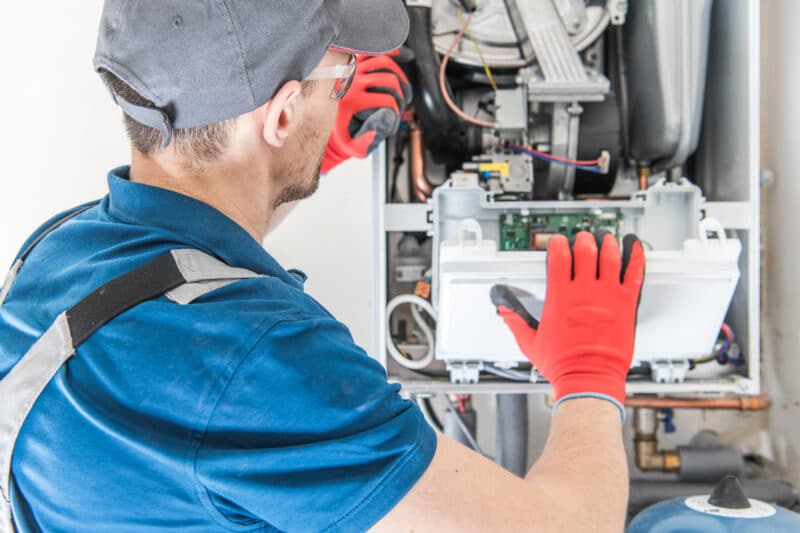 tech repairing an OKC furnace