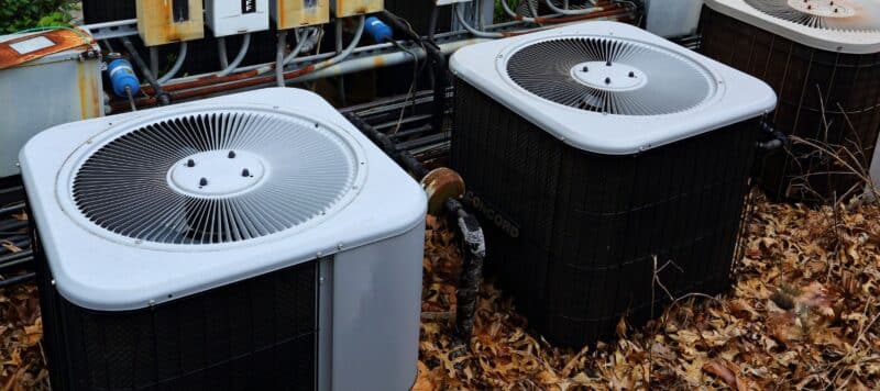 a row of three outdoor ac condenser units installed outside a home