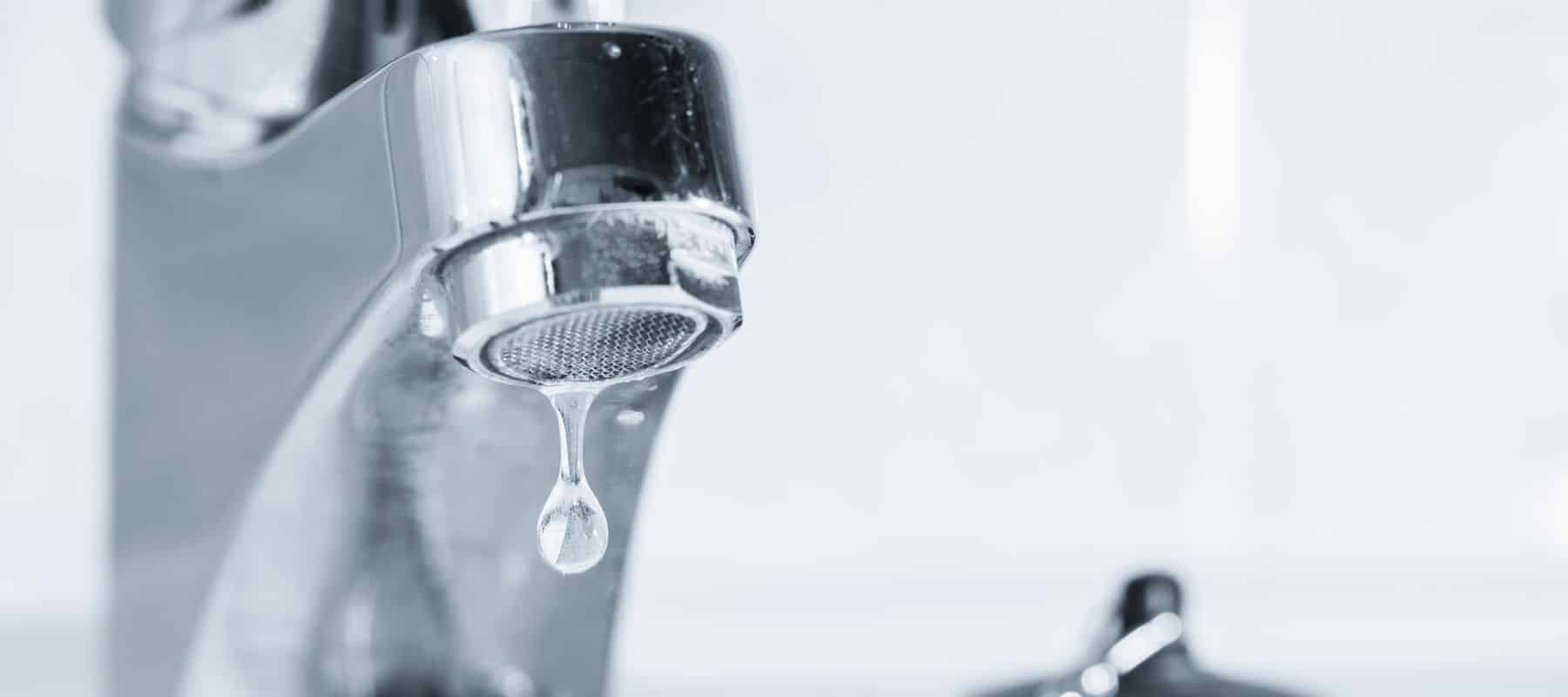 close up of water dripping from sink faucet