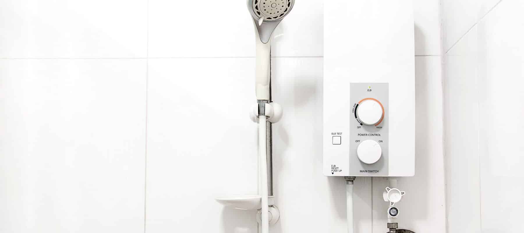 closeup of a water heater installed right next to a removable showerhead ll